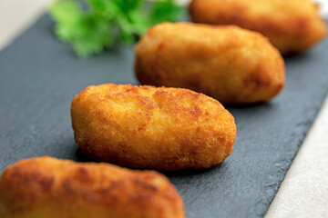 CLOSEUP OF HOMEMADE CROQUETTES IN AIRFRYER. TRADITIONAL SPANISH FOOD COOK BOOK.