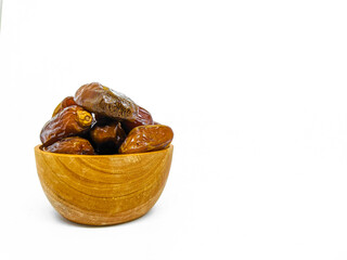 Fresh and healty premium honey tunisia dates (kurma tunisia) in a wooden bowl isolated on white background