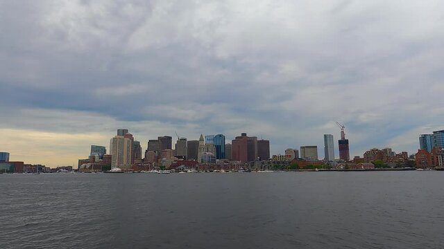 Time lapse video of Boston modern financial district skyline and waterfront in a cloudy day, viewed from East Boston, Massachusetts MA, USA. 