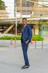 Full length portrait of successful young African businessman wearing suit and tie