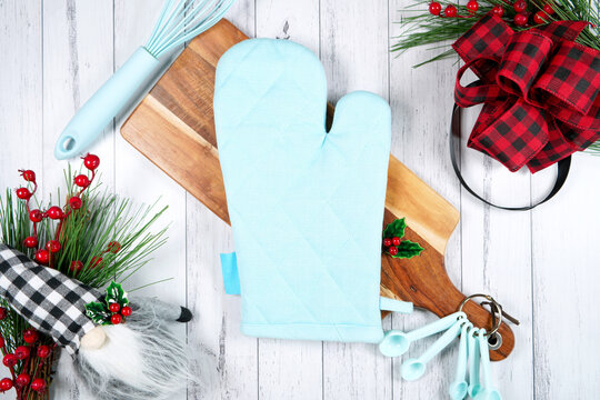 Oven mitt pot holder kitchen product mockup. Christmas farmhouse theme SVG craft product mockup styled with gift with buffalo plaid bow and farmhouse style gnomes against a white wood background.