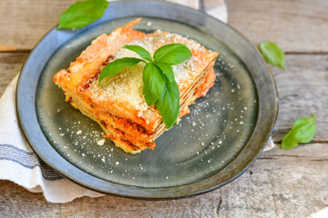   Delicious Home made keto diet  Lasagna bolognese  with  Lupin Flour, minced meat,tomato sauce and spinach  on a wooden rustic  background.Home made low carb italian meal