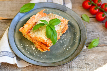   Delicious Home made keto diet  Lasagna bolognese  with  Lupin Flour, minced meat,tomato sauce and spinach  on a wooden rustic  background.Home made low carb italian meal