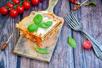   Delicious Home made  ketogenic Lasagna bolognese  with minced meat,tomato sauce and spinach  on a wooden rustic  background.Home made  keto diet italian meal