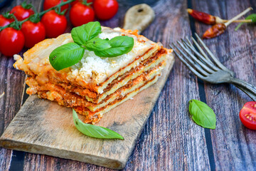   Delicious Home made  ketogenic Lasagna bolognese  with minced meat,tomato sauce and spinach  on a wooden rustic  background.Home made  keto diet italian meal