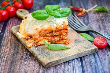   Delicious Home made  ketogenic Lasagna bolognese  with minced meat,tomato sauce and spinach  on a wooden rustic  background.Home made  keto diet italian meal