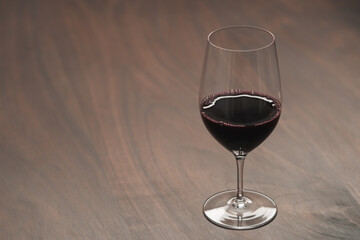 Red wine in wineglass on black walnut table with copy space