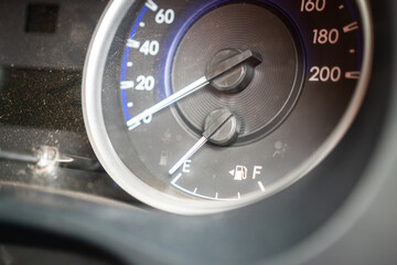 Vehicle fuel level indicator gauge while gasoline in the tank is empty. Transportation equipment object photo. Close-up and selective focus at the index gauge.