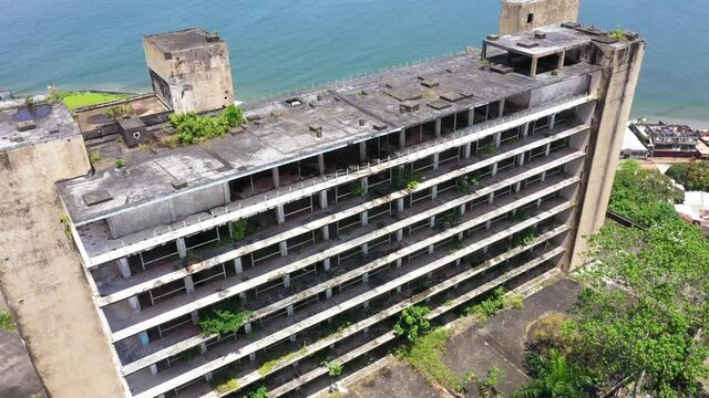 Aerial Monrovia Liberia abandoned luxury hotel climb part 2. West Africa suffers extreme poverty and hunger. Civil war, EBOLA and COVID destruction. Crowded homes and businesses.