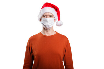 an isolated shot of a happy man in a medical mask from the coronavirus, in casual clothes, an orange sweater, a Christmas hat. Looks at the camera