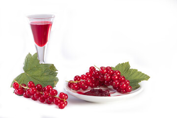 red currant on plate with glass of red juice