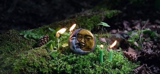 candles and symbol of moon on dark natural forest background. pagan Wiccan, Slavic traditions....