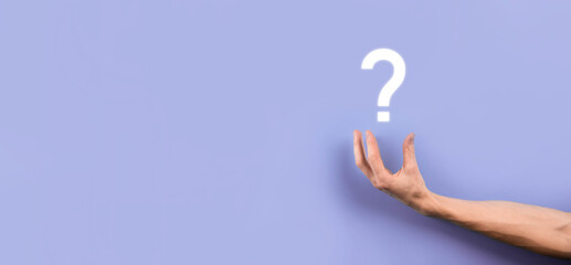 Male hand holding question mark icon on dark background.Banner with copy space. Place for text.