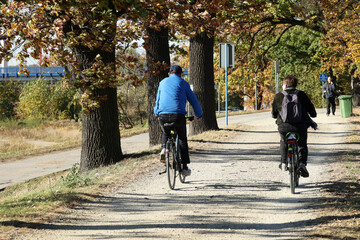 Ludzie jadą na ścieżce rowerowej na rowerze. 