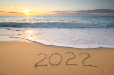 2022 year on the sea shore during sunset - obrazy, fototapety, plakaty