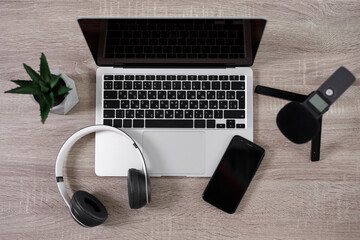 workplace of blogger or journalist - top view of table with laptop, microphone, headphones and smartphone