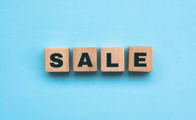 Word Sale of small white cubes next to a bunch of other letters on the surface of the composition on a blue background
