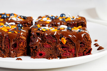 Closeup homemade brownie with cherry on a white plate. Shallow focus.