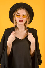 Young girl posing on yellow background half body direct look stylish