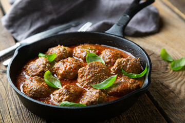 Homemade meatballs in tomato sauce with fresh basil
