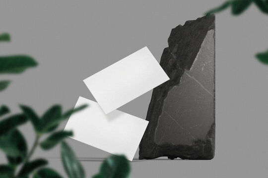 Clean minimal business card mockup floating on black stone with leaves