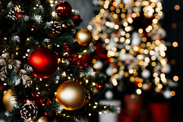 Obraz na płótnie Canvas Beautiful Christmas tree with festive gold, red decor against blurred lights on background, closeup. Christmas and New Year concept. Background with copyspace, your text space.