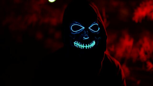 The devilish woman is death. An image of a creepy Halloween in neon light at night on the street