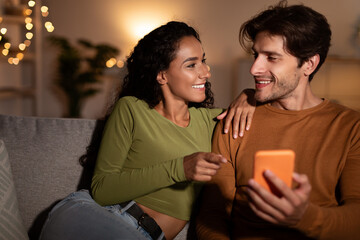 Couple Using Cellphone, Wife Pointing Finger At Phone At Home