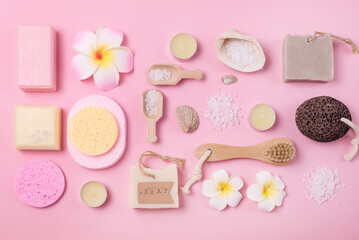 Flay Lay Sea Salt Aroma Candles Face Sponges Bamboo Face Brush Plumeria Flower Natural Soap Scoop with Salt Shell Pumice Pink Background SPA concept Top View Horizontal Wellness