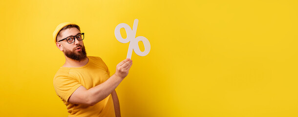 man hold percentage symbol over yellow background,  panoramic layout