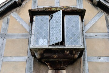 Hanging enclosed balcony with vintage glass windows in a historic half-timbered house in England, UK