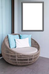 Empty brown plastic rattan sofa and blank photo frame on the balcony of the house