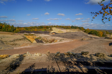 Landschaft eines Steinbruchs in bewaldeter Gegend mit blauem Himmel