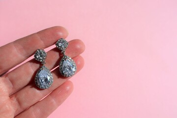 Crystal diamond jewel earrings held in hand
