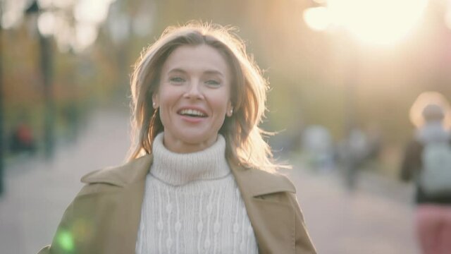 Caucasian female correspondent talking while being on air in news from center city street. Adult attractive blogger in the city centre. High quality 4k footage