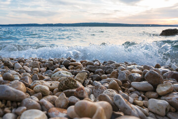 Fototapeta na wymiar Mysterious view of stones and pebbles in water after sunset.
