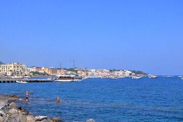 boats in front of the coast and beach in Ischia, Italy