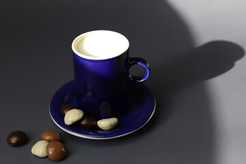 Blue cup with milk and small blue plate with chocolate cookies for early breakfast on sunny morning.