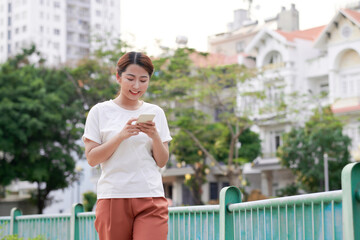 Portrait of a beautiful young woman standing outside using mobile phone