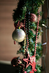Winter. Christmas decoration on a rustic chair.
Christmas ornament, red - gold color,  with shining lamps.