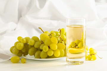 Glass of grape juice and grape cluster.