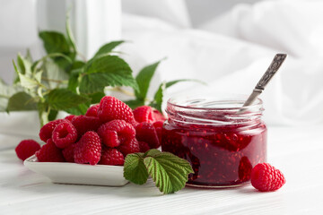 Jar of raspberry jam and fresh berries.