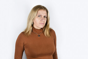 Portrait of a mature woman on a light background with emotions of suspicion, distrust, as if she...