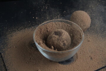 chocolate cake falls flying roll in cocoa powder. Preparation of dessert