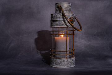 metalowa szara lampa ze świecą na szarym tle izolowana i minimalistyczna