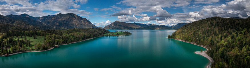 Fototapeta na wymiar Mountain panorama of turquoise coloured Lake Walchensee with blue sky from above, Bavaria.