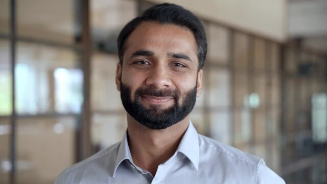 Happy Smiling Bearded Indian Business Man Small Business Owner, Company Leader Or Sales Manager, Male Hispanic Ceo Executive, Successful Lawyer Looking At Camera Standing In Office, Headshot Portrait.