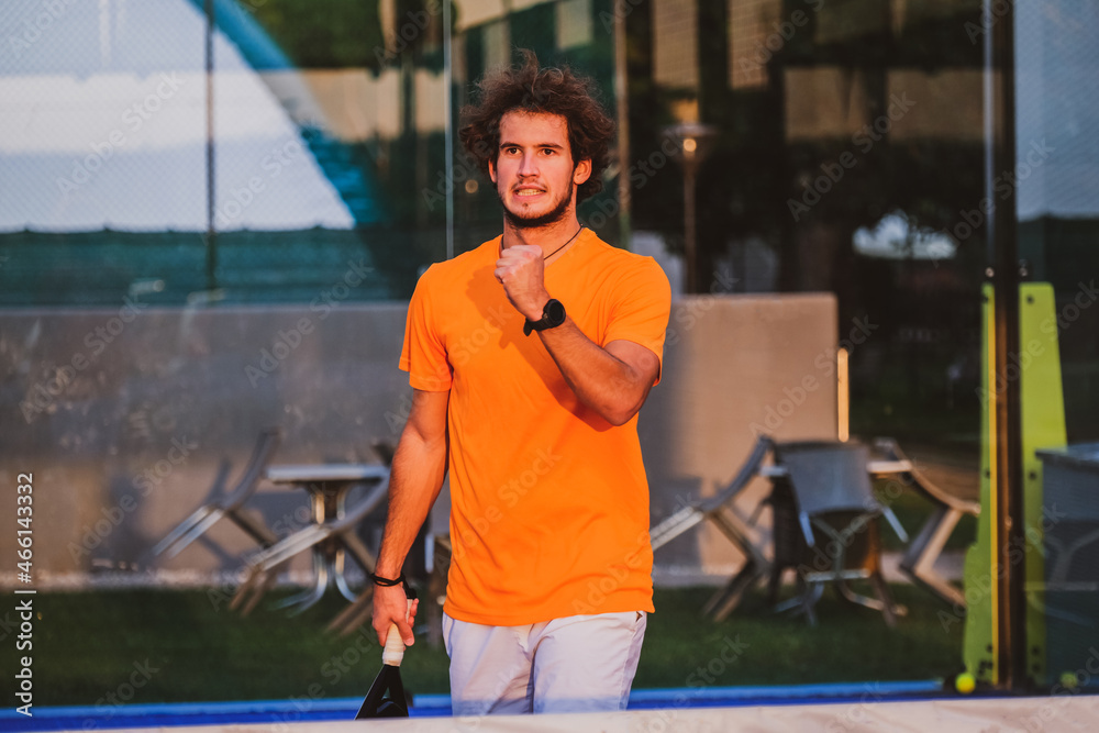 Wall mural Padel player exulting after winning a match - Young athlete celebrating victory after good play