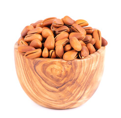 Pine nuts in olive bowl, isolated on white background. Heap of roasted pine nuts in shells.