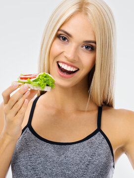 Portrait image of happy excited woman eating vegetarian sandwich. Beautiful blond amazed smiling girl in dieting, loss weight and vegetarian concept.
